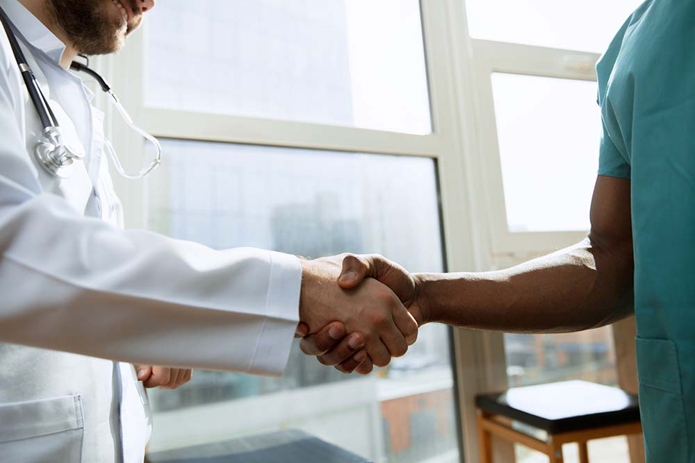 Close up photo of two doctors shaking hands