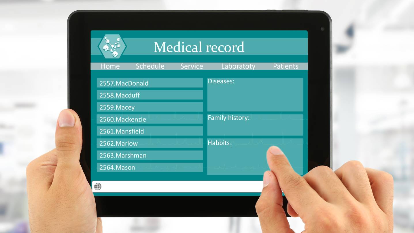 Hands holding a tablet that shows a blank electronic medical record