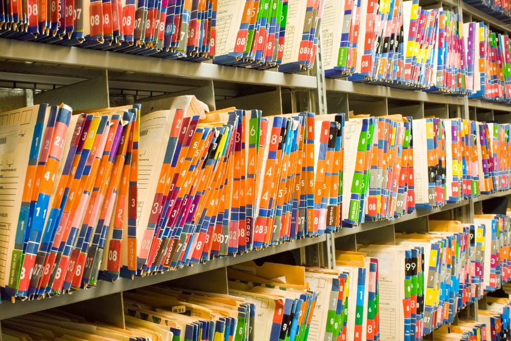 Shelves containing colourful medical records file folders